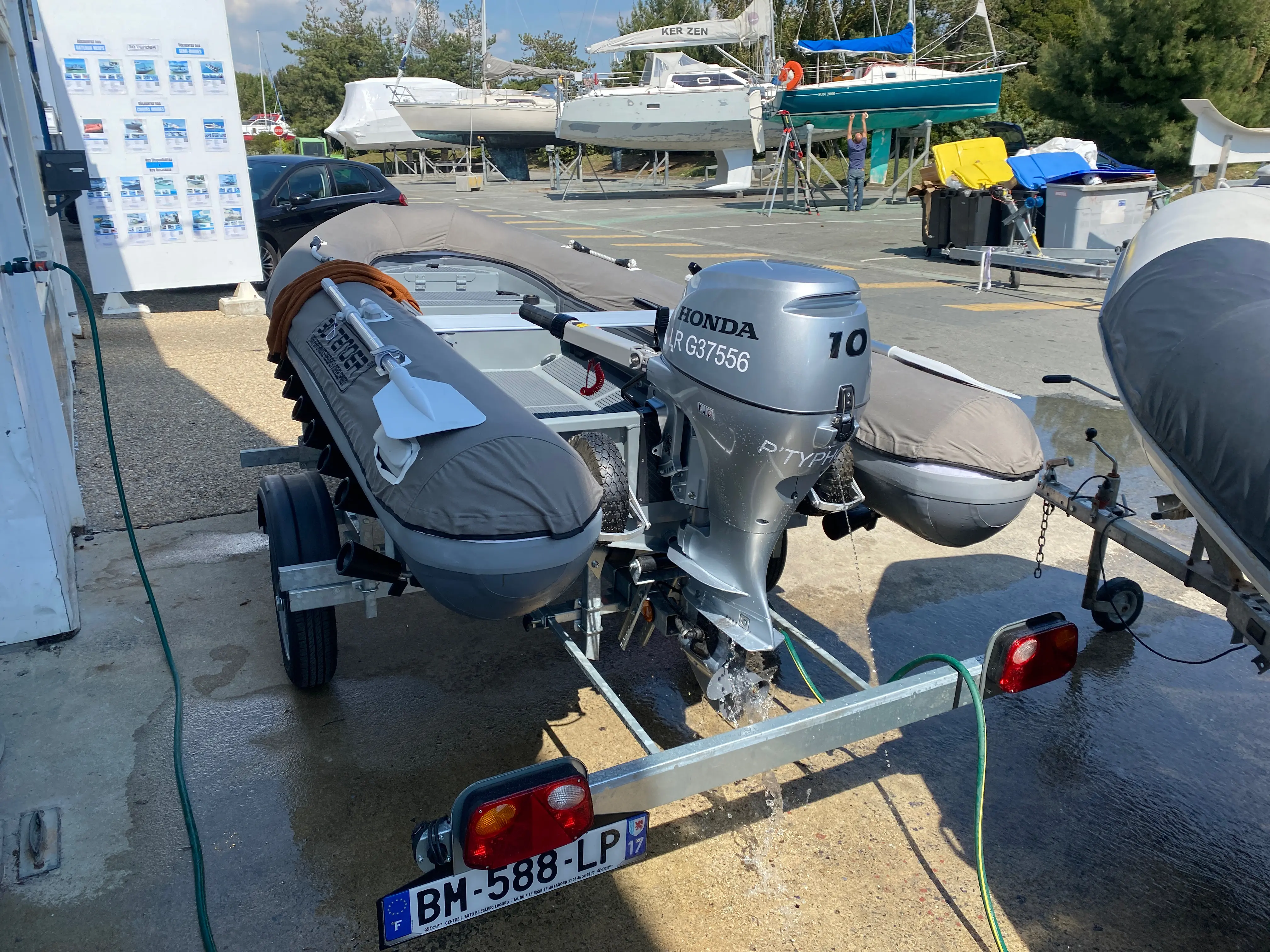 3D Tender Ultimate Rib 340 — Bateau pneumatique sur remorque avec moteur hors-bord dans un port à sec.