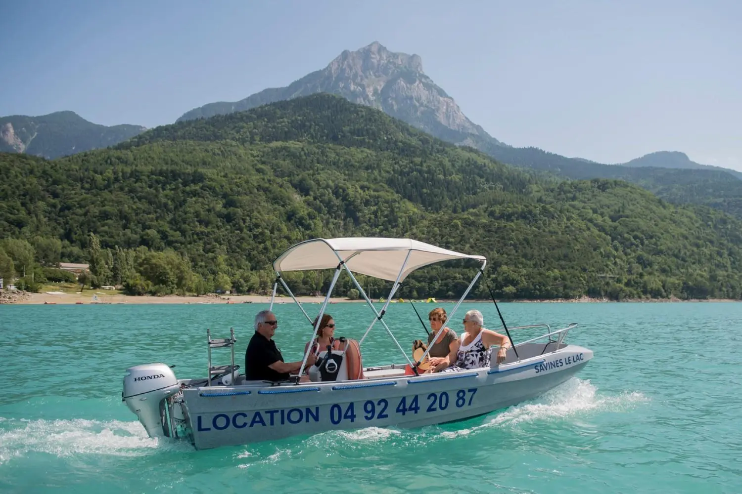 Fun Yak 450 — Bateau à moteur avec taud et passagers naviguant sur un lac alpin.