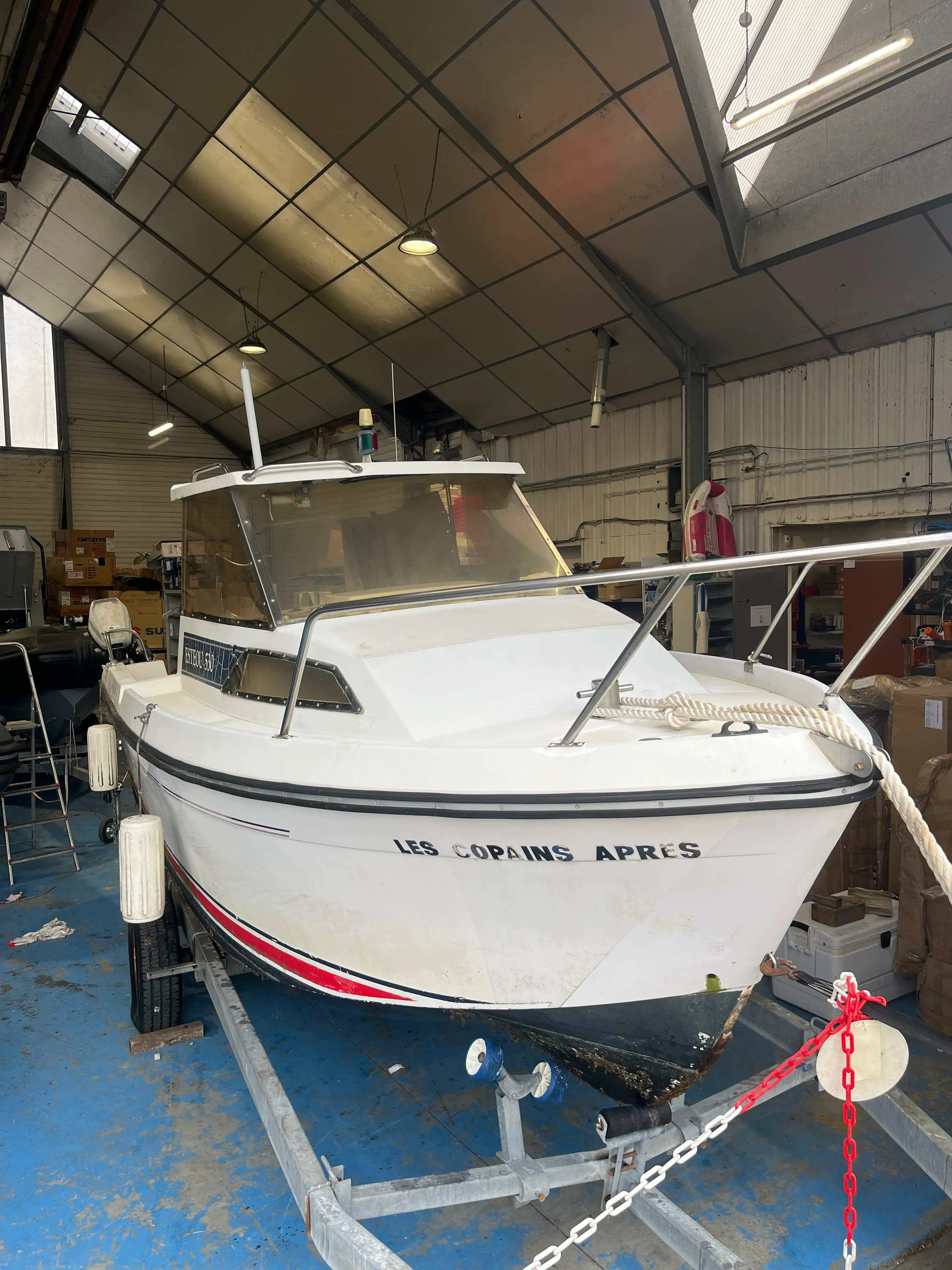 Jeanneau Esteou 530 — Bateau à moteur blanc photographié de face dans un atelier.