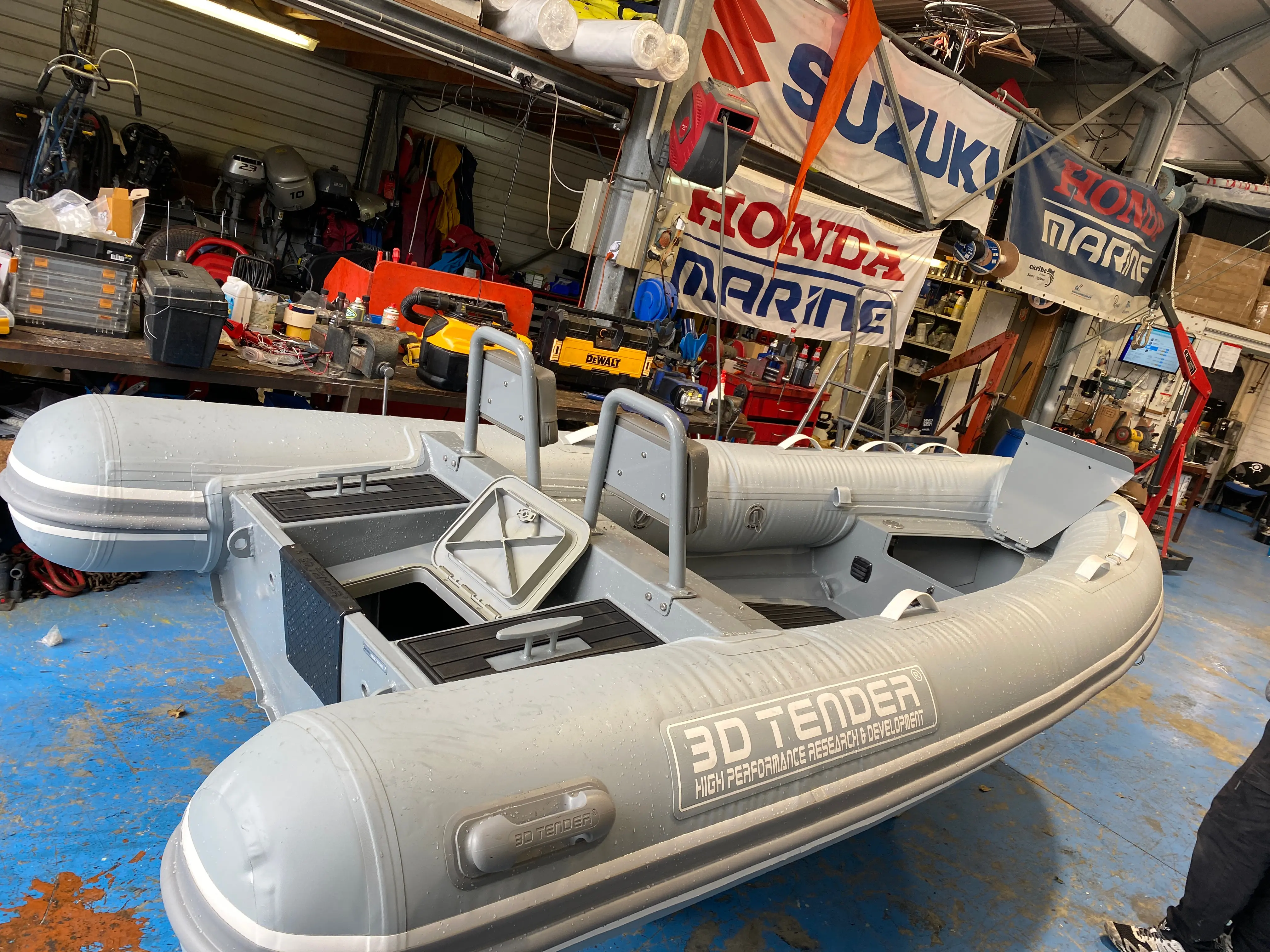 3D Tender Dream 340 — Bateau pneumatique gris photographié dans un atelier, vu de trois quarts.