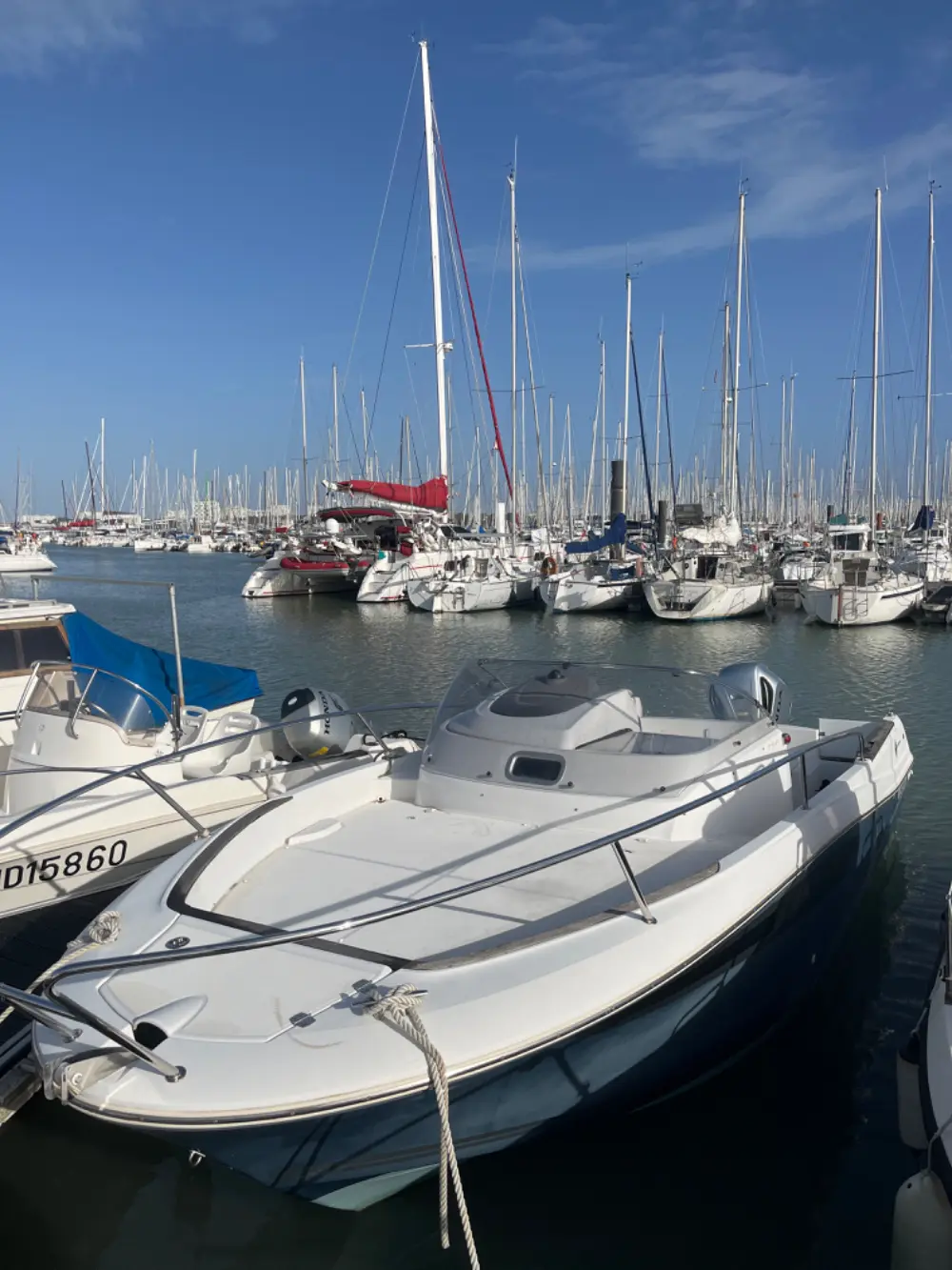 Jeanneau Cap Camarat 750 — Bateau à moteur amarré dans un port de plaisance, entouré de voiliers.