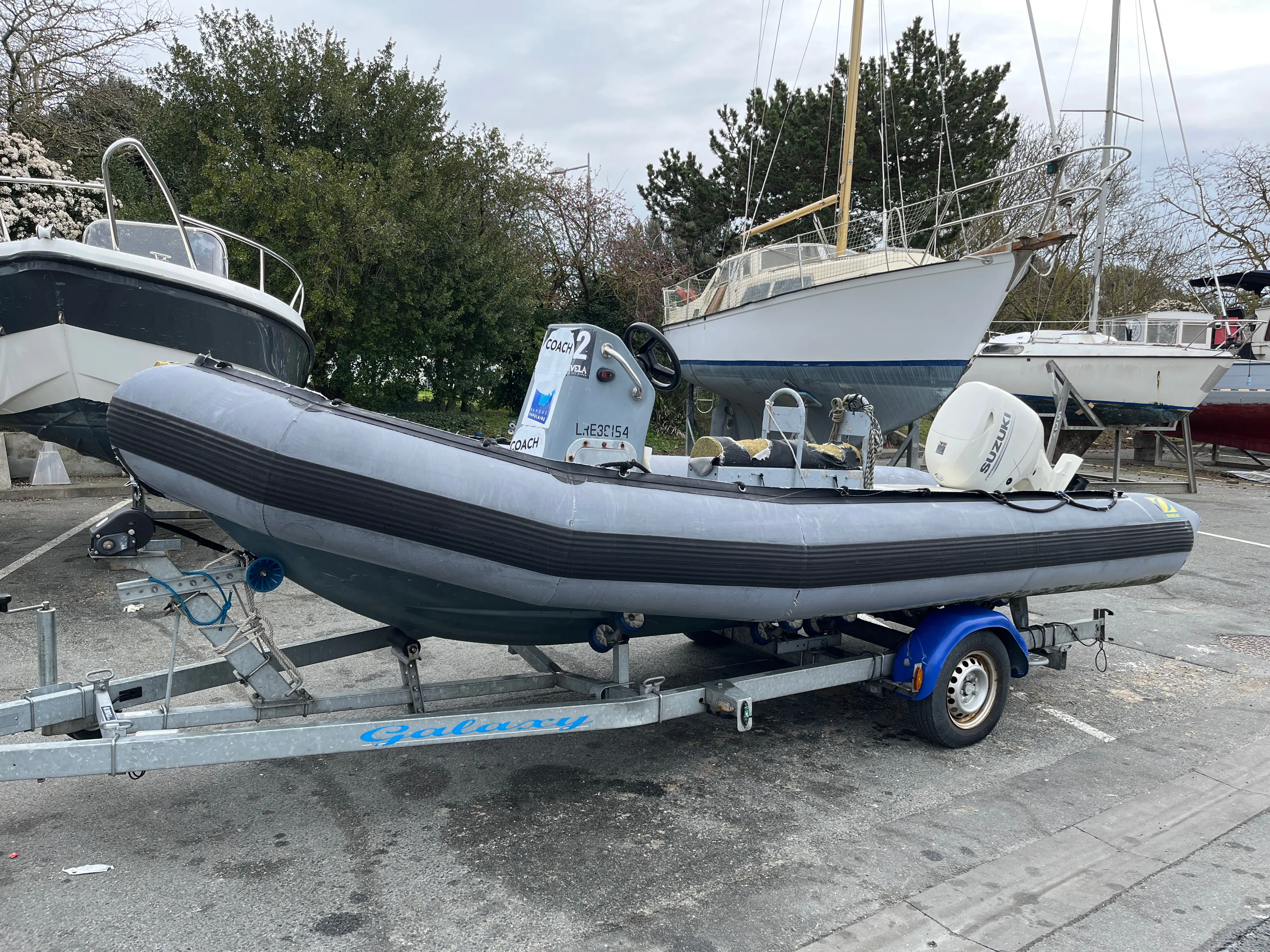 Zodiac 550 SRMN — Bateau pneumatique gris à console centrale, posé sur une remorque dans un chantier naval.