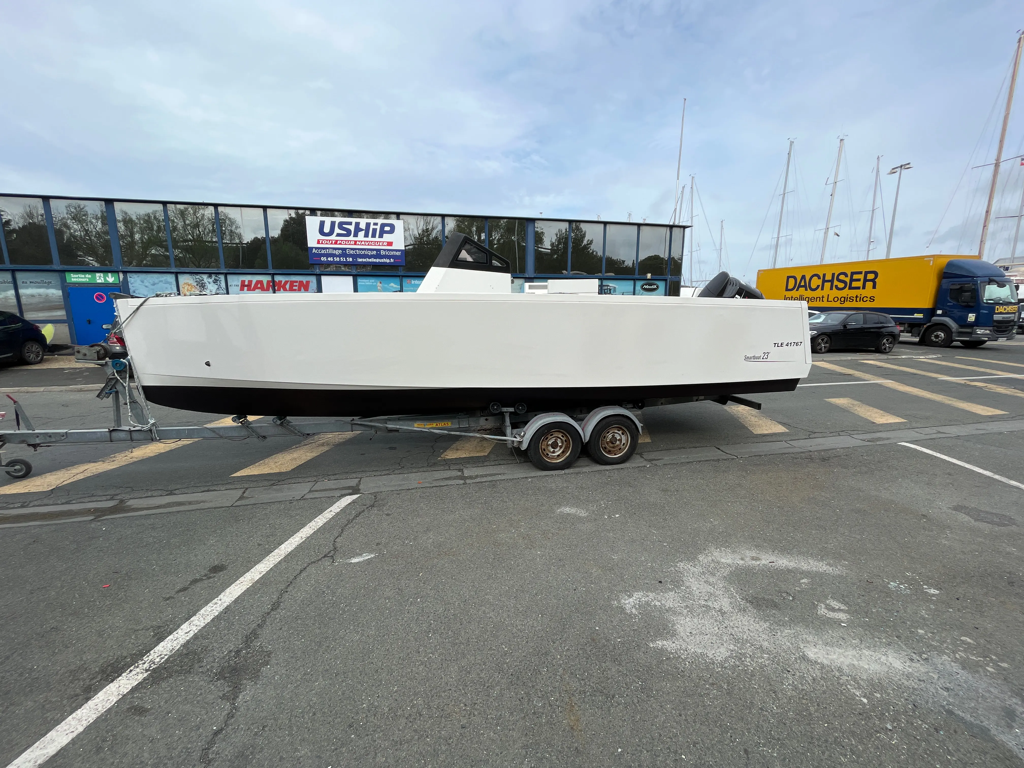 Smartboat 23 — Bateau blanc présenté sur remorque, photographié de profil sur un parking.