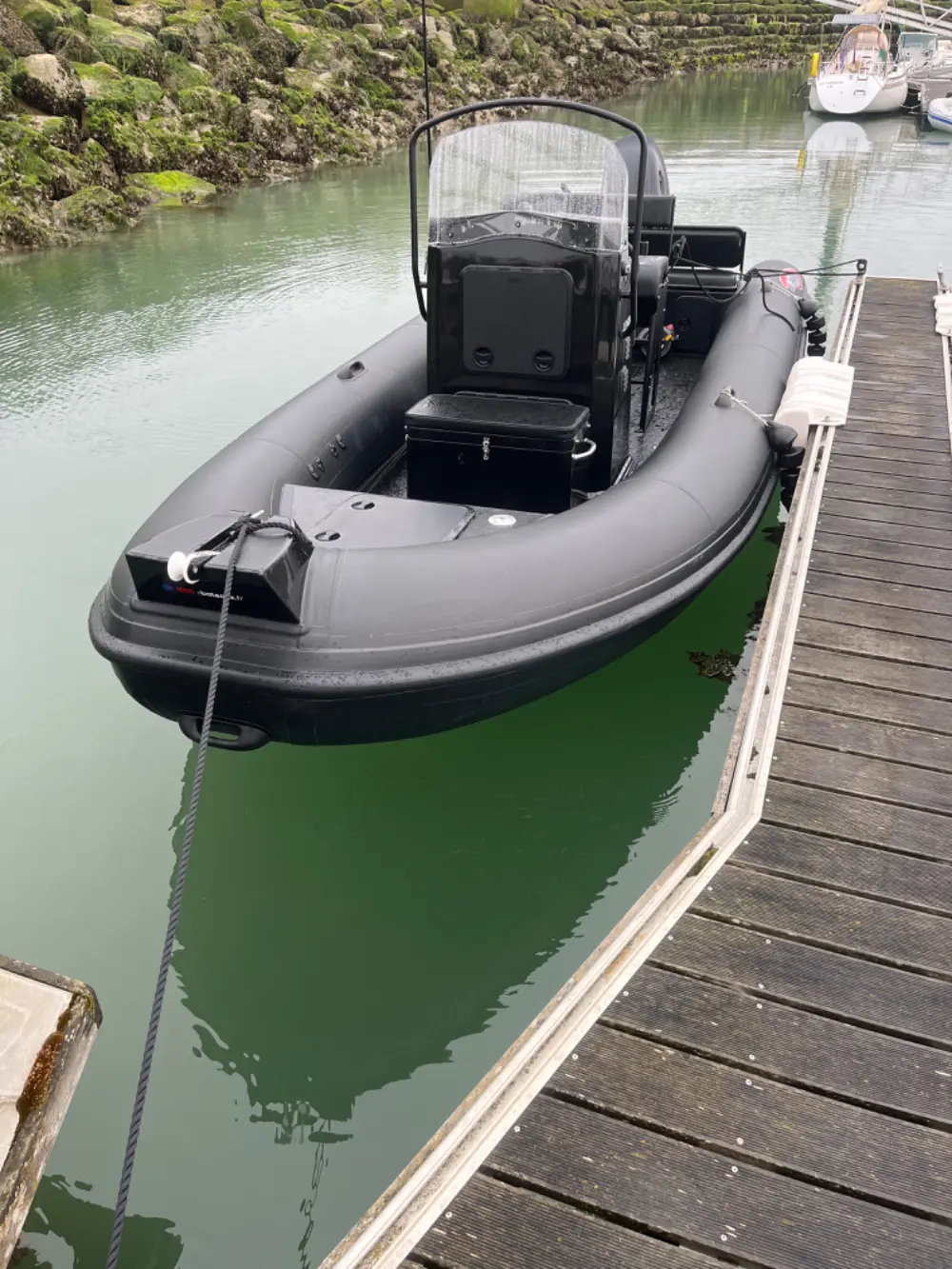 Searib`s Open 670 — Semi-rigide noir amarré à un ponton, avec console centrale et banquette arrière.