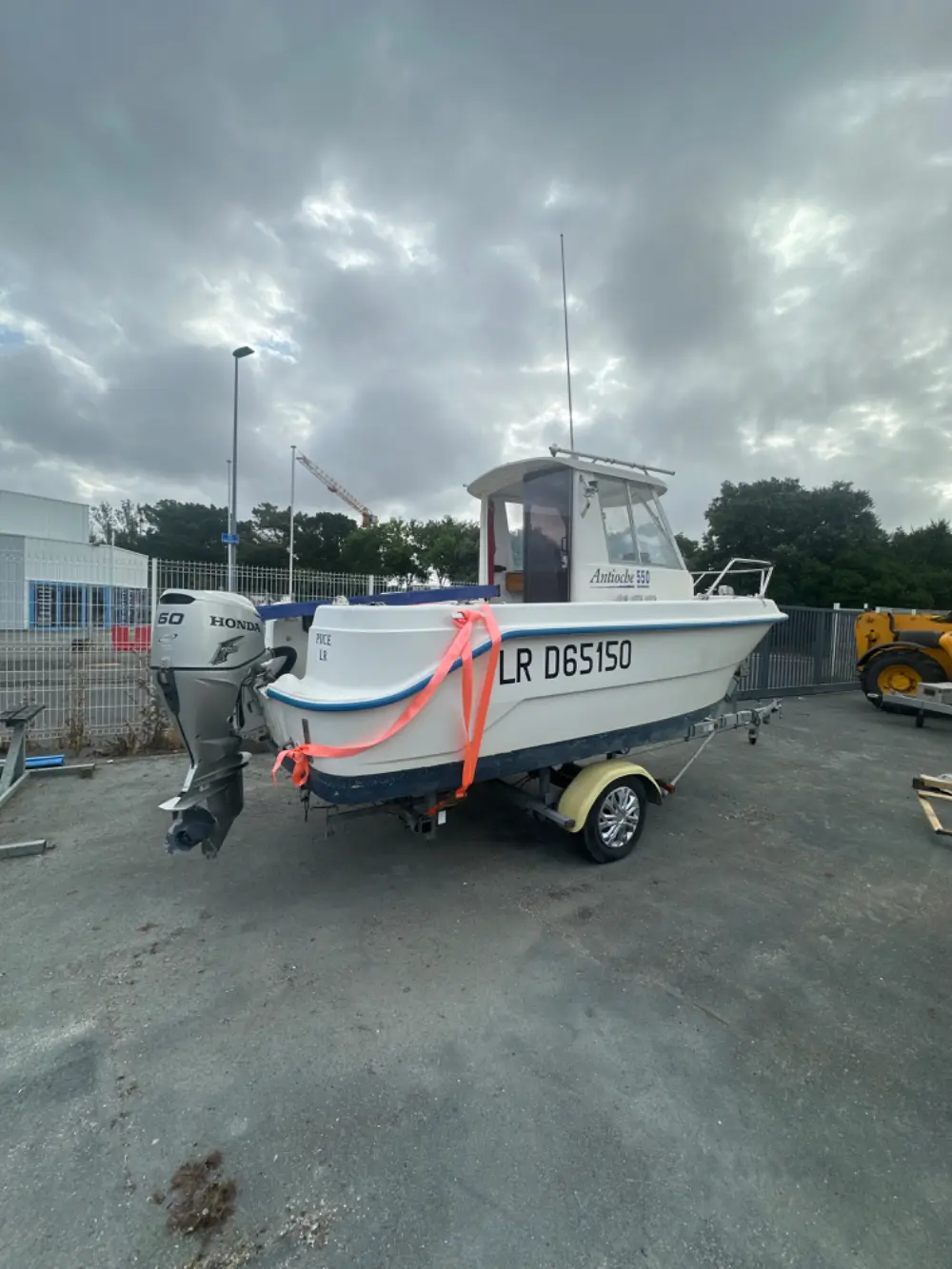 Guymarine Antioche — Bateau à moteur blanc photographié sur remorque dans une aire extérieure.