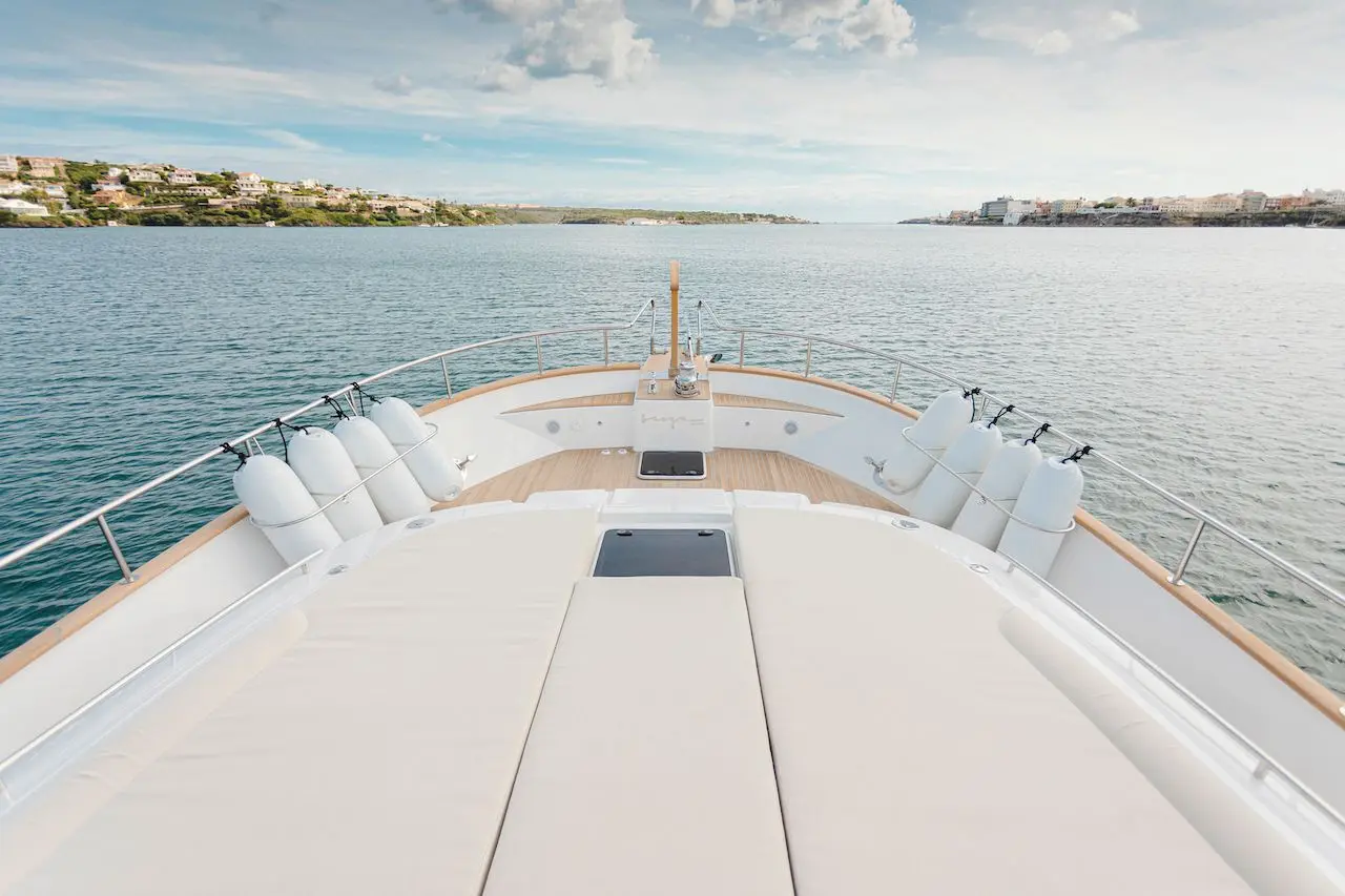 Sasga Menorquin 68 — Vue du pont avant d’un bateau, avec la côte en arrière-plan.