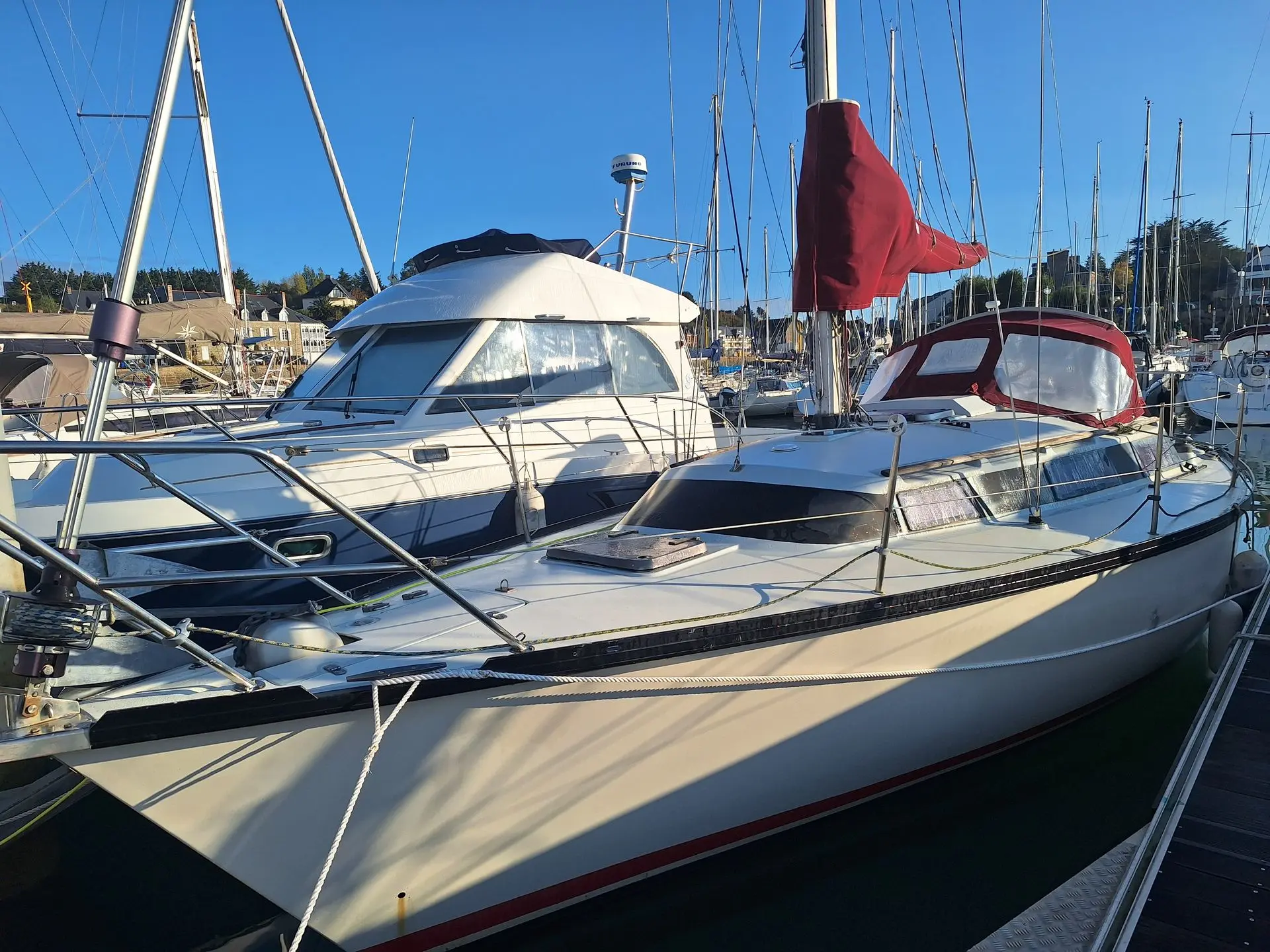 Dufour 3800 — Voilier blanc amarré dans un port, photographié de trois quarts avant.