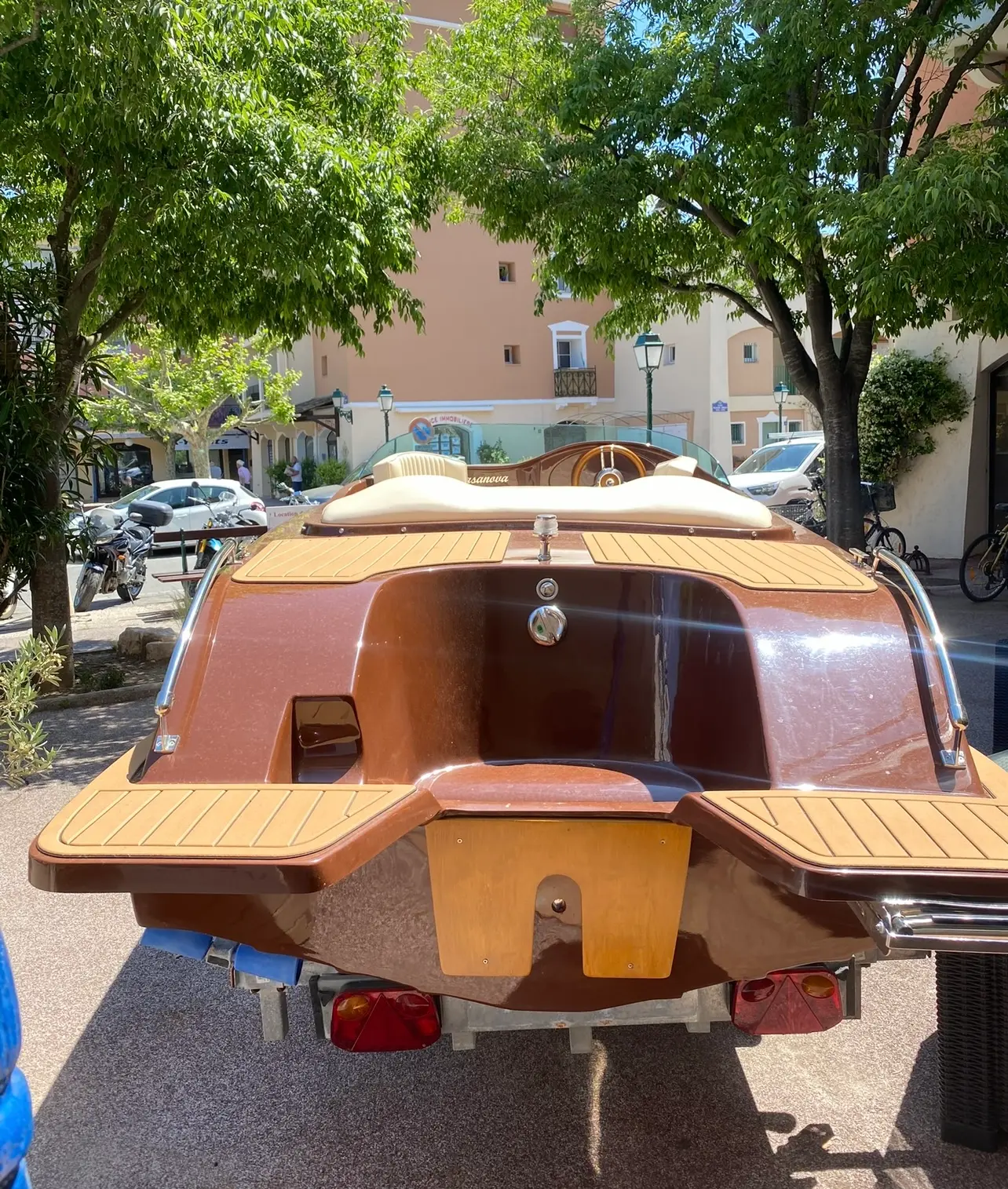 Kruger 23 Casanova — Vue arrière d’un bateau en bois exposé sur une remorque.