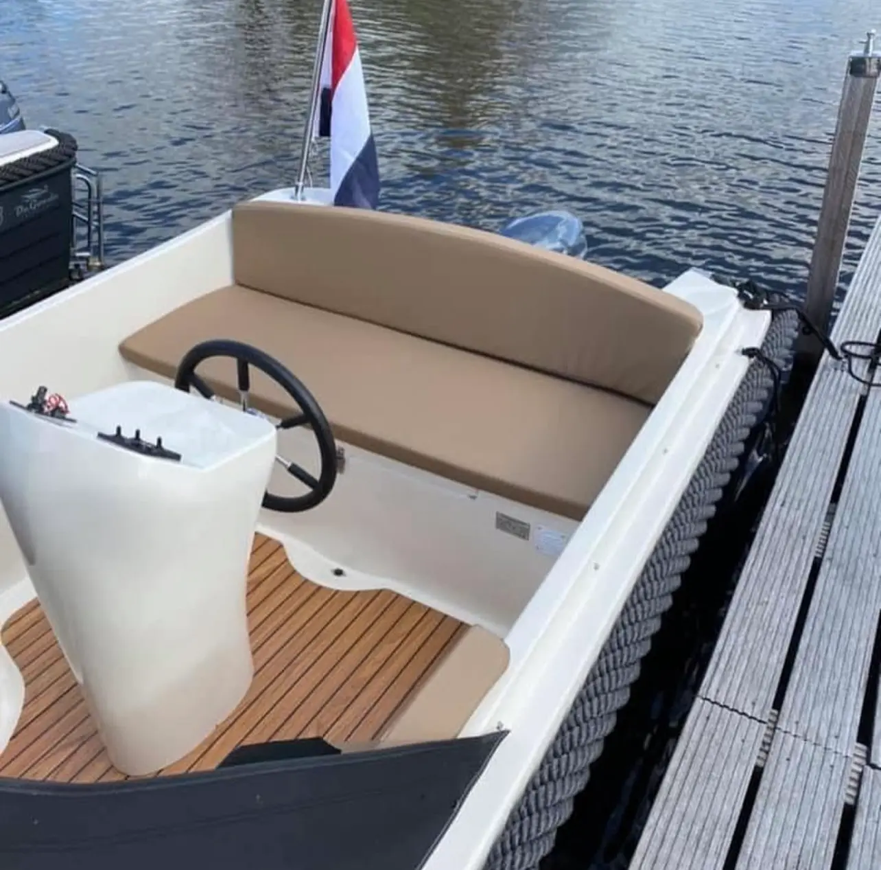 Kruger Delta — Vue du cockpit avec banquette, poste de pilotage et plancher en teck.