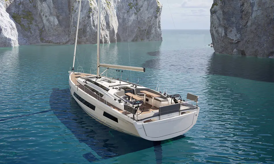 Dufour 48 — Voilier vu de trois quarts arrière dans une crique aux falaises rocheuses.