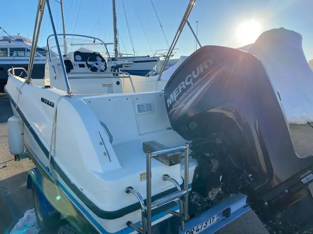 Quicksilver 505 Open — Vue arrière d’un bateau blanc équipé d’un moteur hors-bord Mercury.