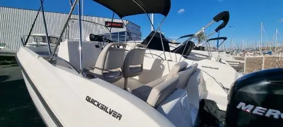 Quicksilver Activ 535 Open — Bateau à moteur blanc vu de trois quarts, amarré dans un port de plaisance.