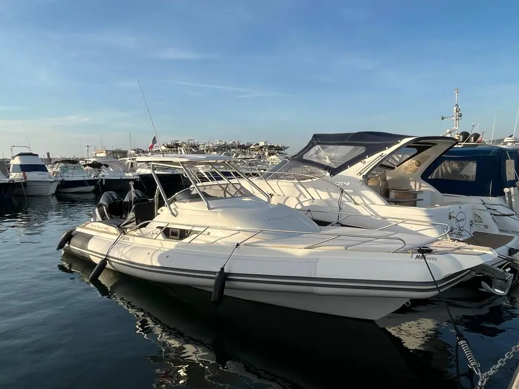Nuova Jolly Prince 33 Sport Cabine — Bateau semi-rigide blanc amarré dans un port de plaisance.