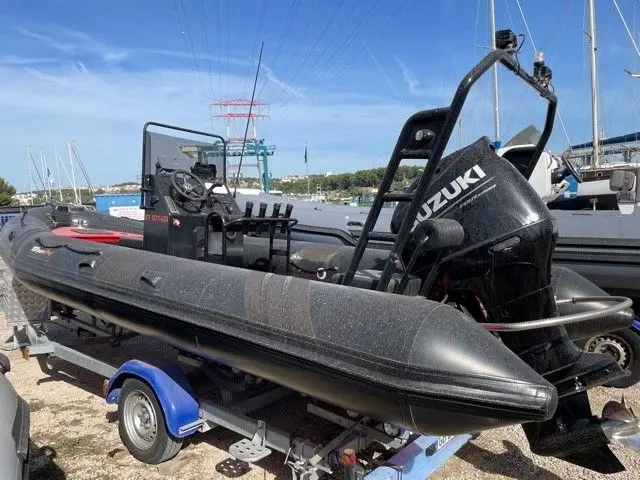 Tarpon DV65 — Bateau pneumatique semi-rigide noir sur remorque, photographié à terre dans un port.