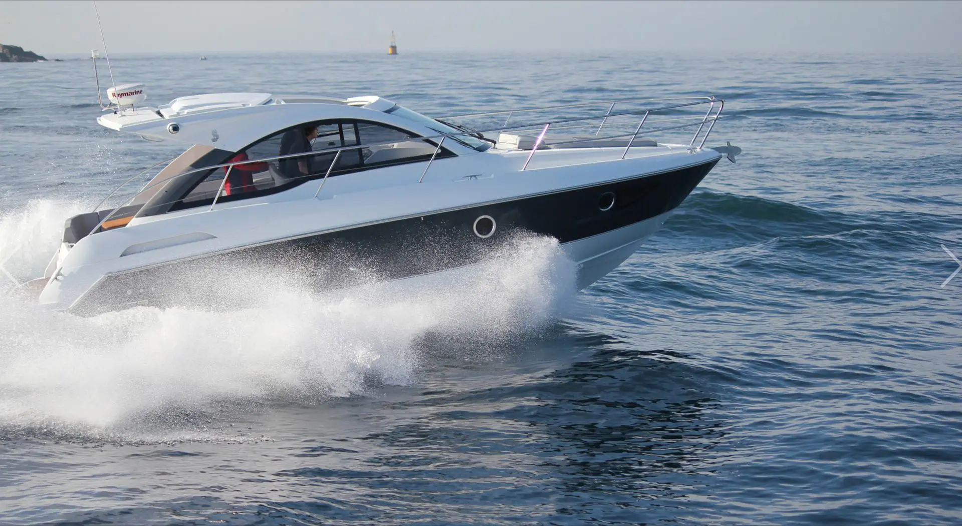Beneteau Gran Turismo 34 — Bateau à moteur blanc et noir naviguant rapidement sur la mer.