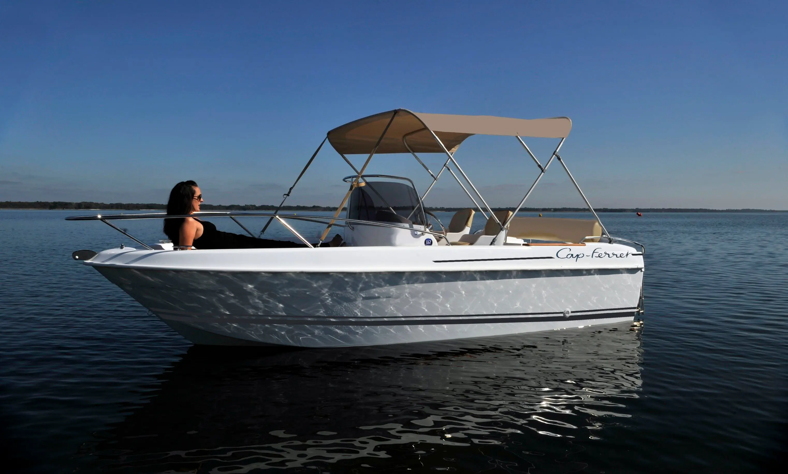 B2 Marine Cap Ferret 522 — Bateau à moteur blanc photographié de profil sur une étendue d’eau calme.