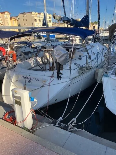 Dufour 36 — Voilier blanc amarré au port, vu de trois quarts depuis le quai.