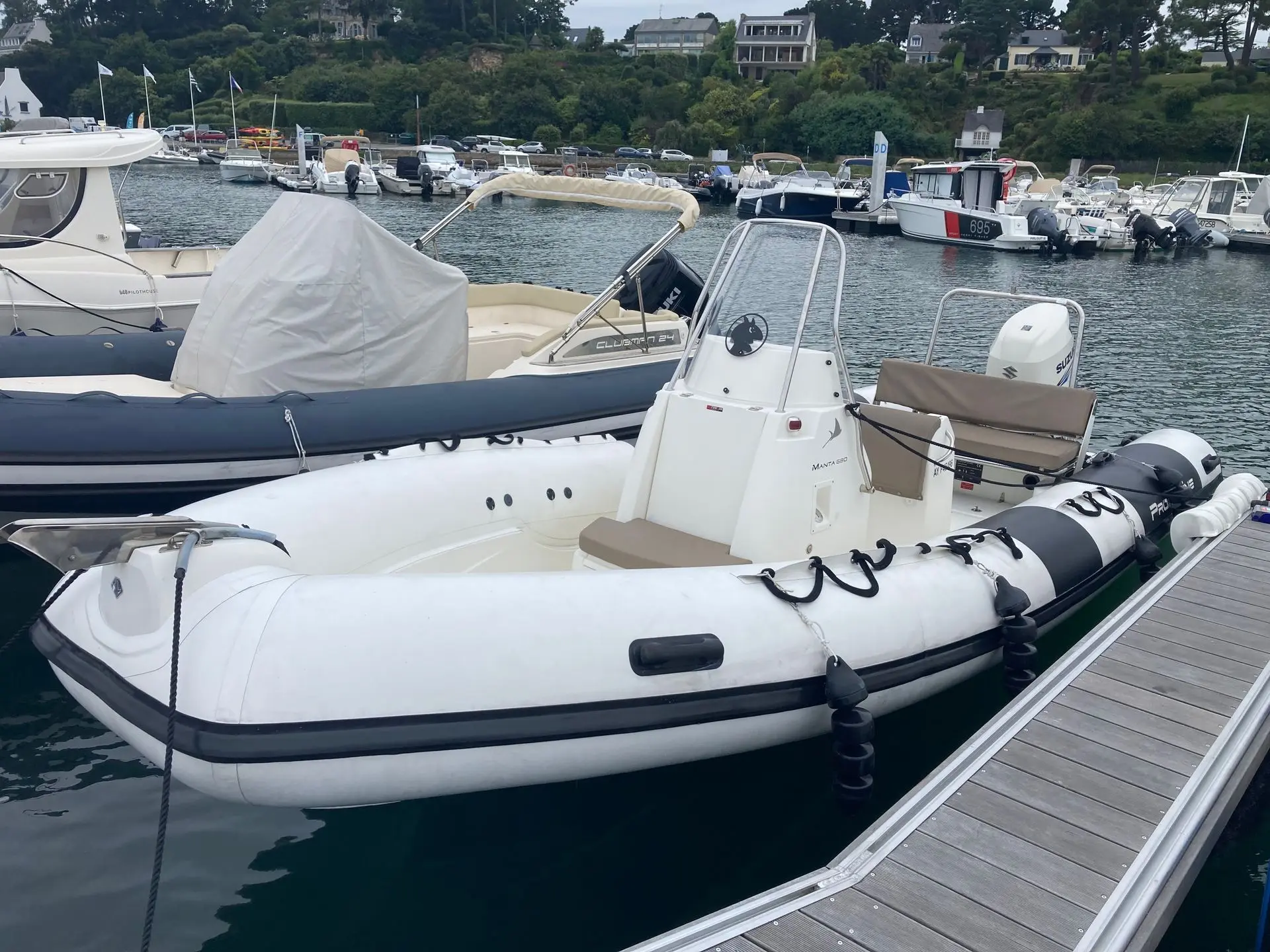 Pro Marine Manta 680 — Bateau pneumatique blanc amarré dans un port, photographié depuis le ponton.