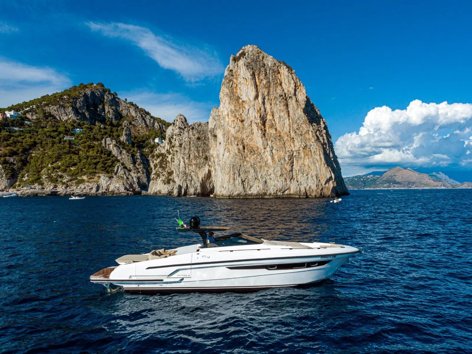 Rio Yachts Daytona 46 — Bateau à moteur blanc naviguant devant des falaises en bord de mer.