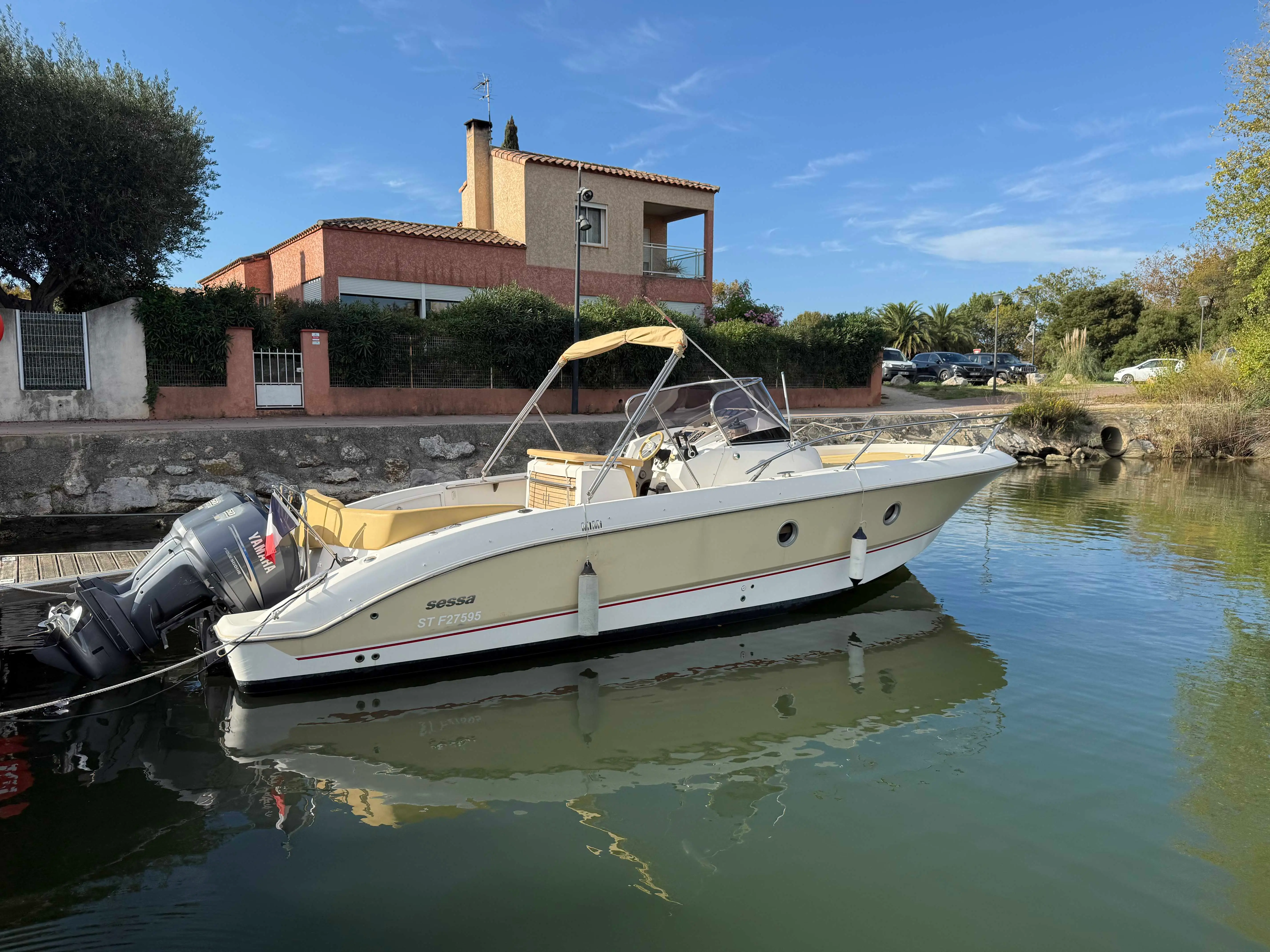 Sessa Marine Key Largo 28 — Bateau à moteur blanc amarré dans un canal, vu de trois quarts bâbord.