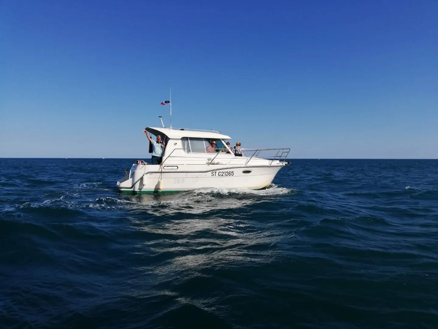 Ocqueteau 765 — Bateau à cabine naviguant au large, photographié de profil sur une mer calme.