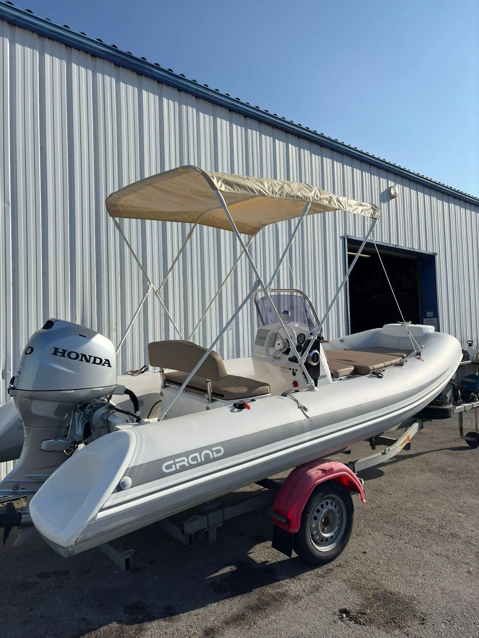 Grand Silver Line S 470 N — Bateau semi-rigide blanc équipé d’un bimini, d’une console centrale et d’un moteur hors-bord.