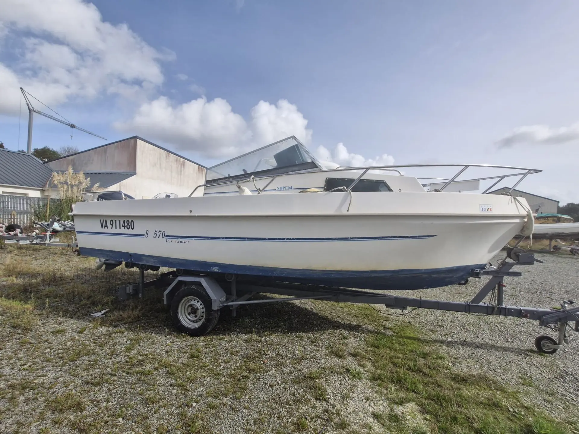 SBPEM S 570 — Bateau à moteur blanc photographié sur remorque dans une cour extérieure.