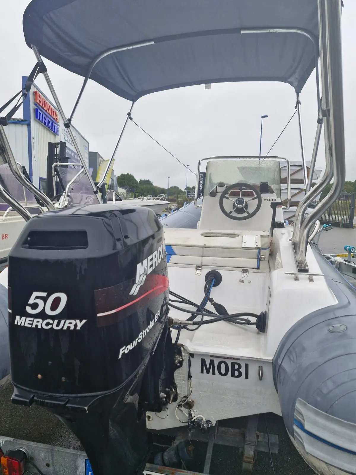Sacs S 475 — Vue arrière d’un bateau semi-rigide avec moteur hors-bord et taud de soleil.