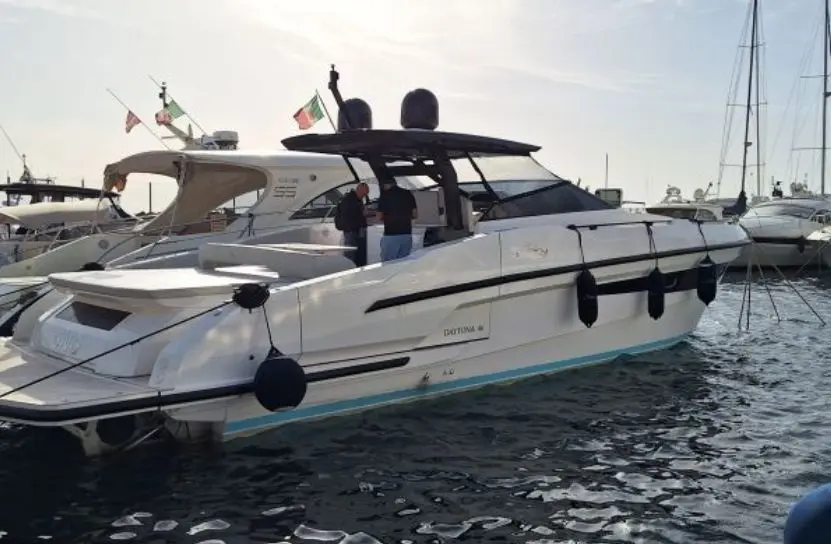 Rio Yachts Daytona 46 — Bateau à moteur blanc vu de trois quarts dans un port, amarré entre d'autres embarcations.
