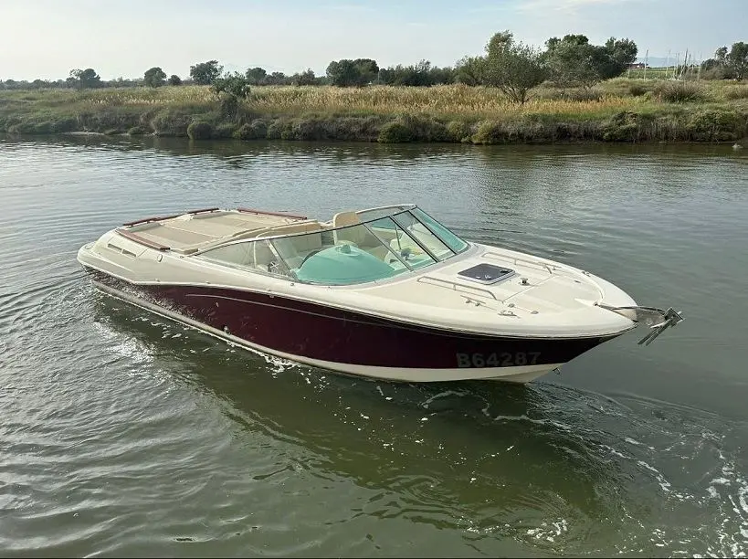 Jeanneau Runabout 755 — Bateau à moteur blanc et bordeaux naviguant sur un canal, vu de trois quarts.
