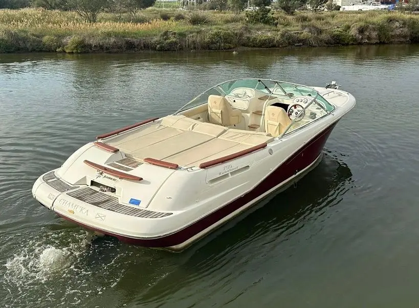 Jeanneau Runabout 755 — Bateau à moteur blanc et bordeaux naviguant sur un canal.