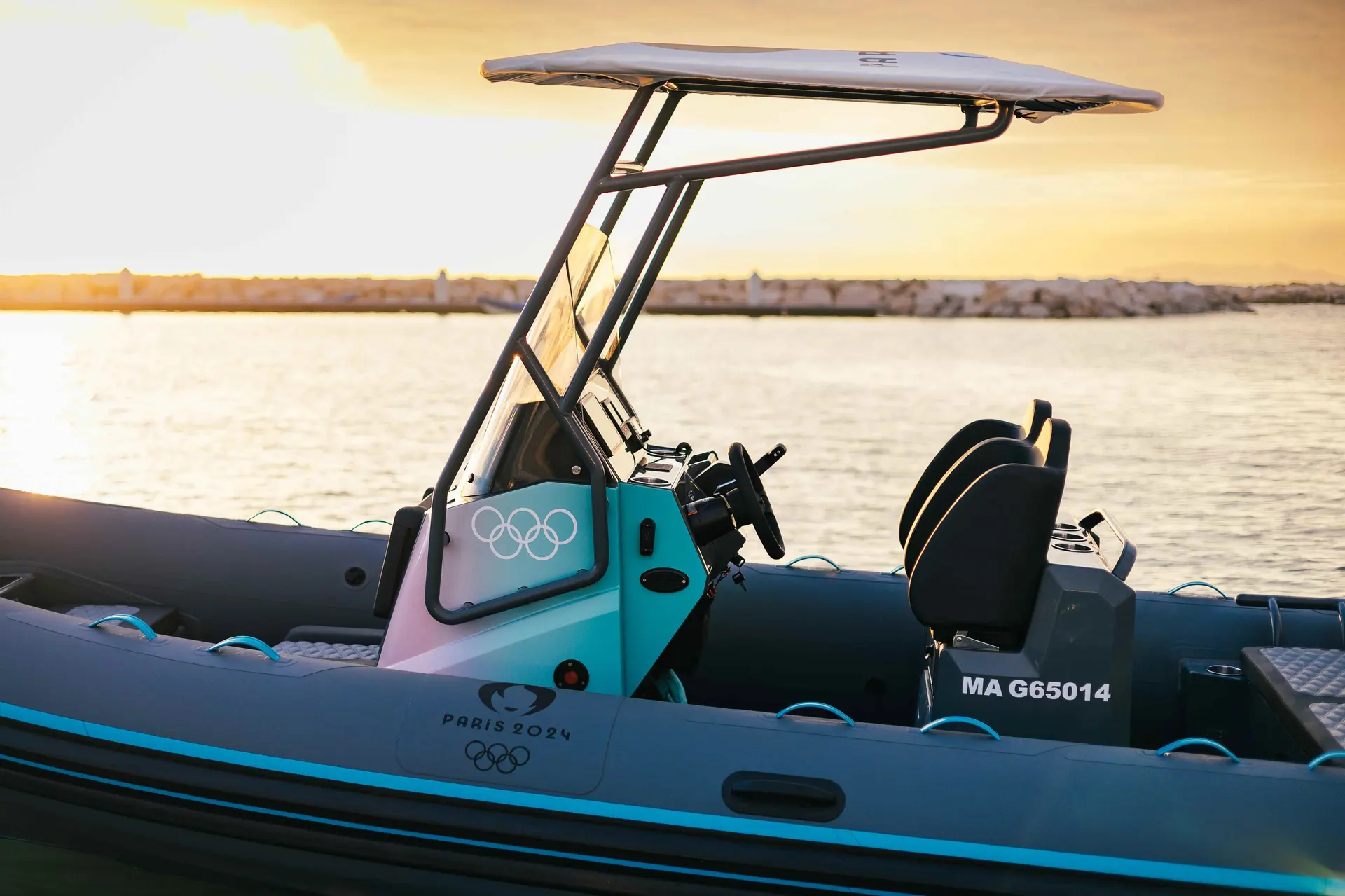 Highfield sport 600 JO — Vue latérale partielle d’un semi-rigide avec console centrale et arceau au coucher du soleil.