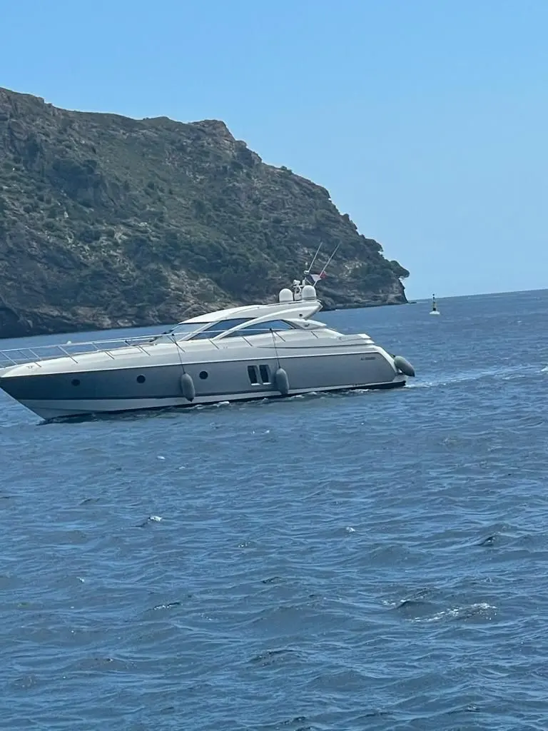 Sessa Marine C52 — Bateau à moteur naviguant au large d'une côte rocheuse.