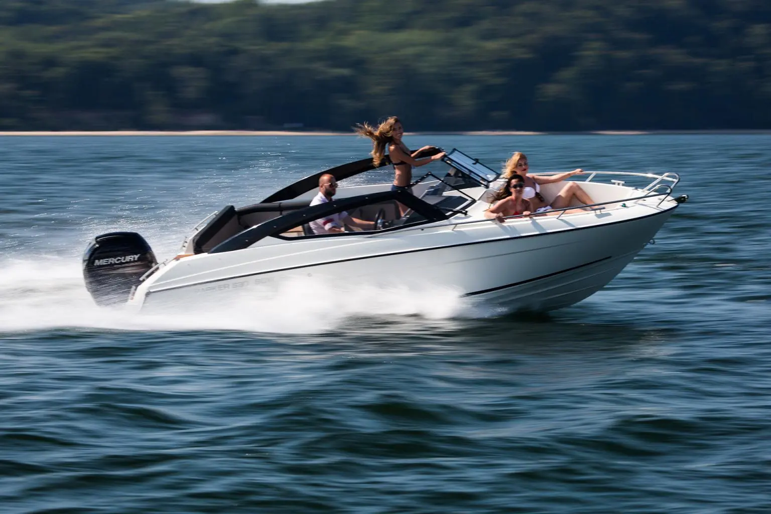 Parker 630 Bow Rider — Bateau à moteur blanc naviguant rapidement sur un lac avec plusieurs passagers.