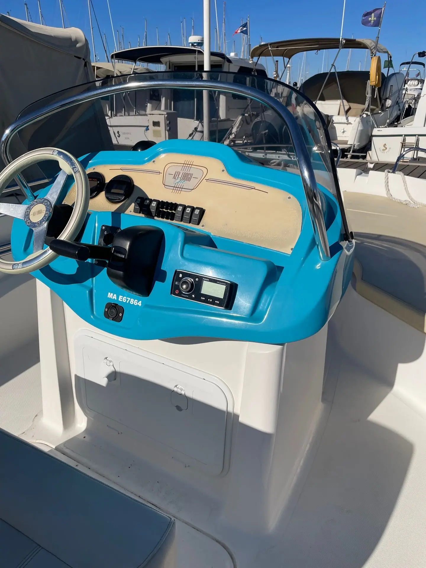 Sessa Marine Key Largo One — Poste de pilotage bleu et blanc d’un bateau amarré dans une marina.