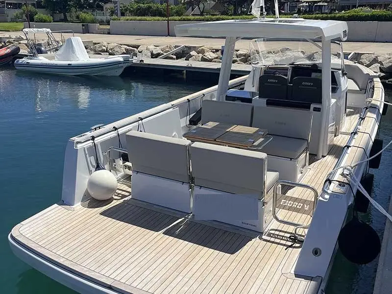 Fjord 38 Open — Vue arrière d’un bateau à moteur amarré, avec cockpit et banquettes extérieures.