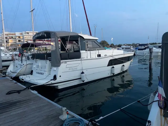 Delphia 1100 — Bateau à moteur blanc amarré dans une marina, vu de trois quarts arrière.
