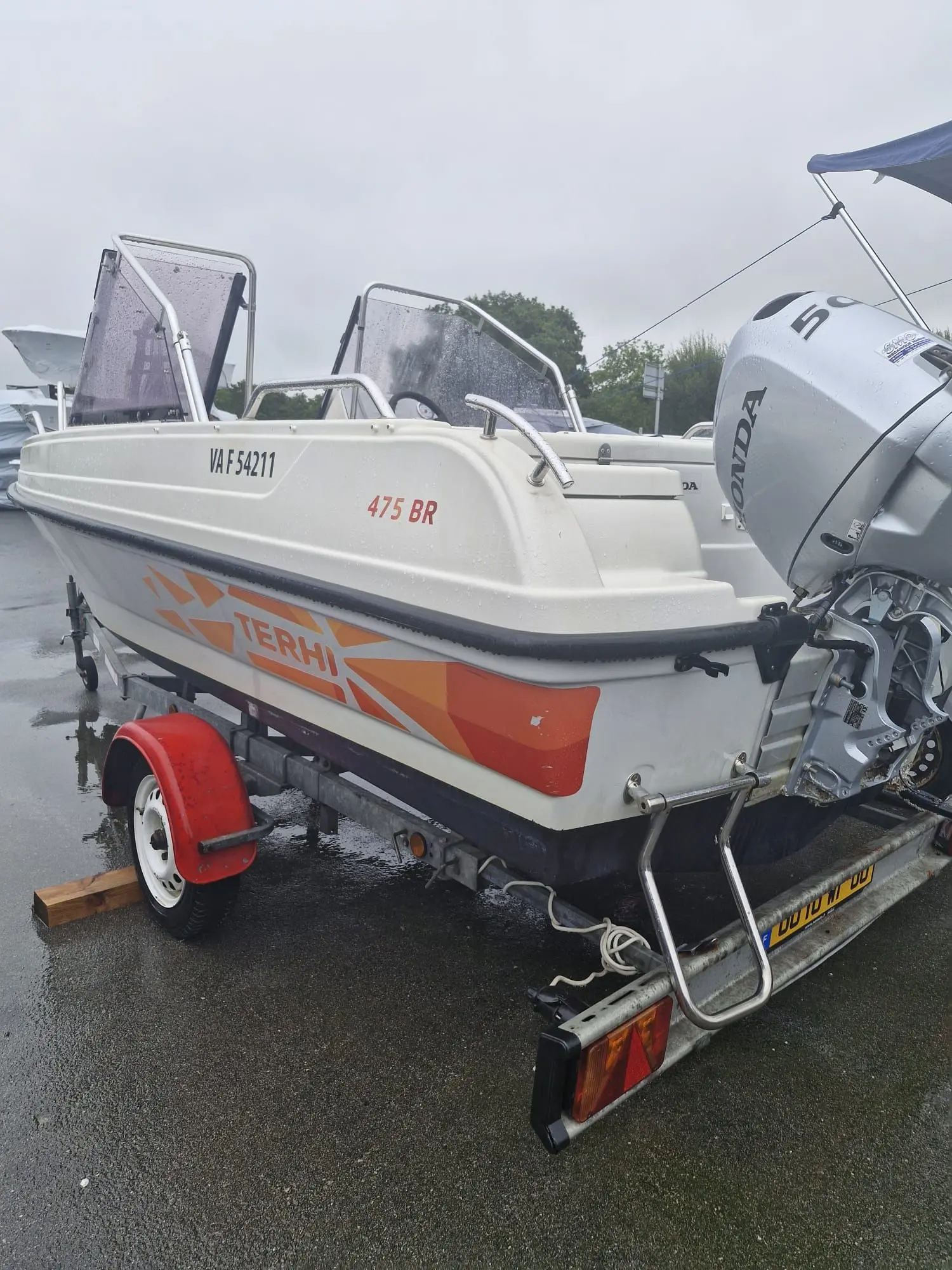 Terhi 475 Br — Bateau Terhi blanc et orange sur remorque, photographié par l’arrière sous la pluie.