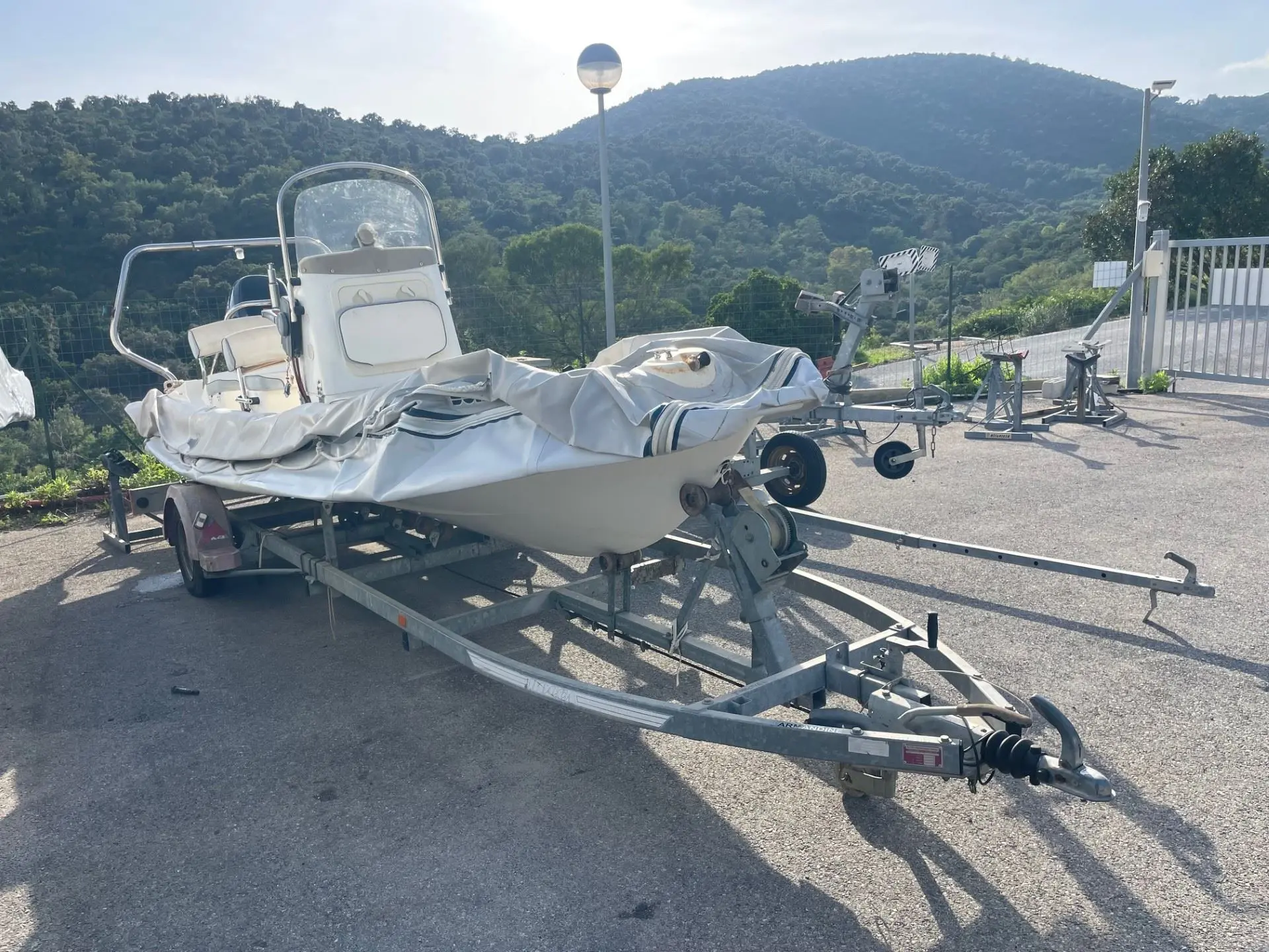 Bombard Explorer 620 — Bateau à console centrale bâché, posé sur une remorque dans un parking.