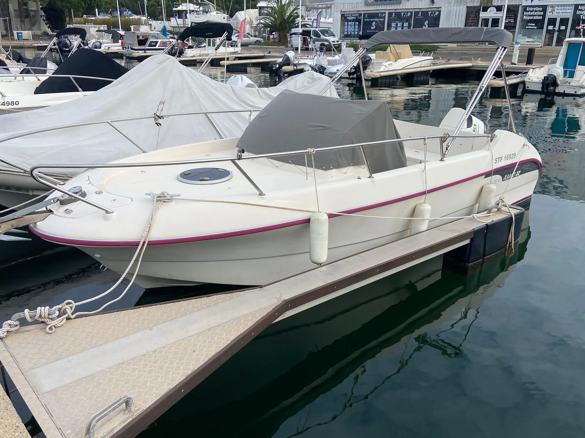 Ocqueteau Abaco 22 — Bateau à moteur amarré dans un port, vu de trois quarts avant.