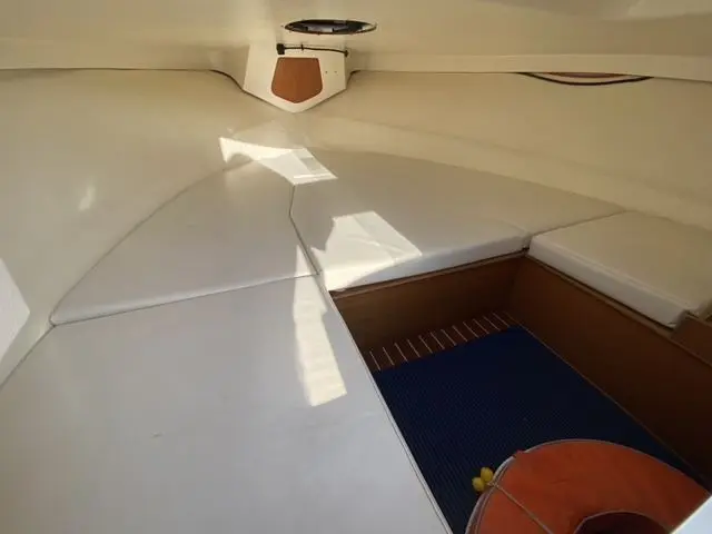 Ocqueteau Abaco 22 — Vue intérieure d’un espace de couchage avec coussins blancs et sol bleu.