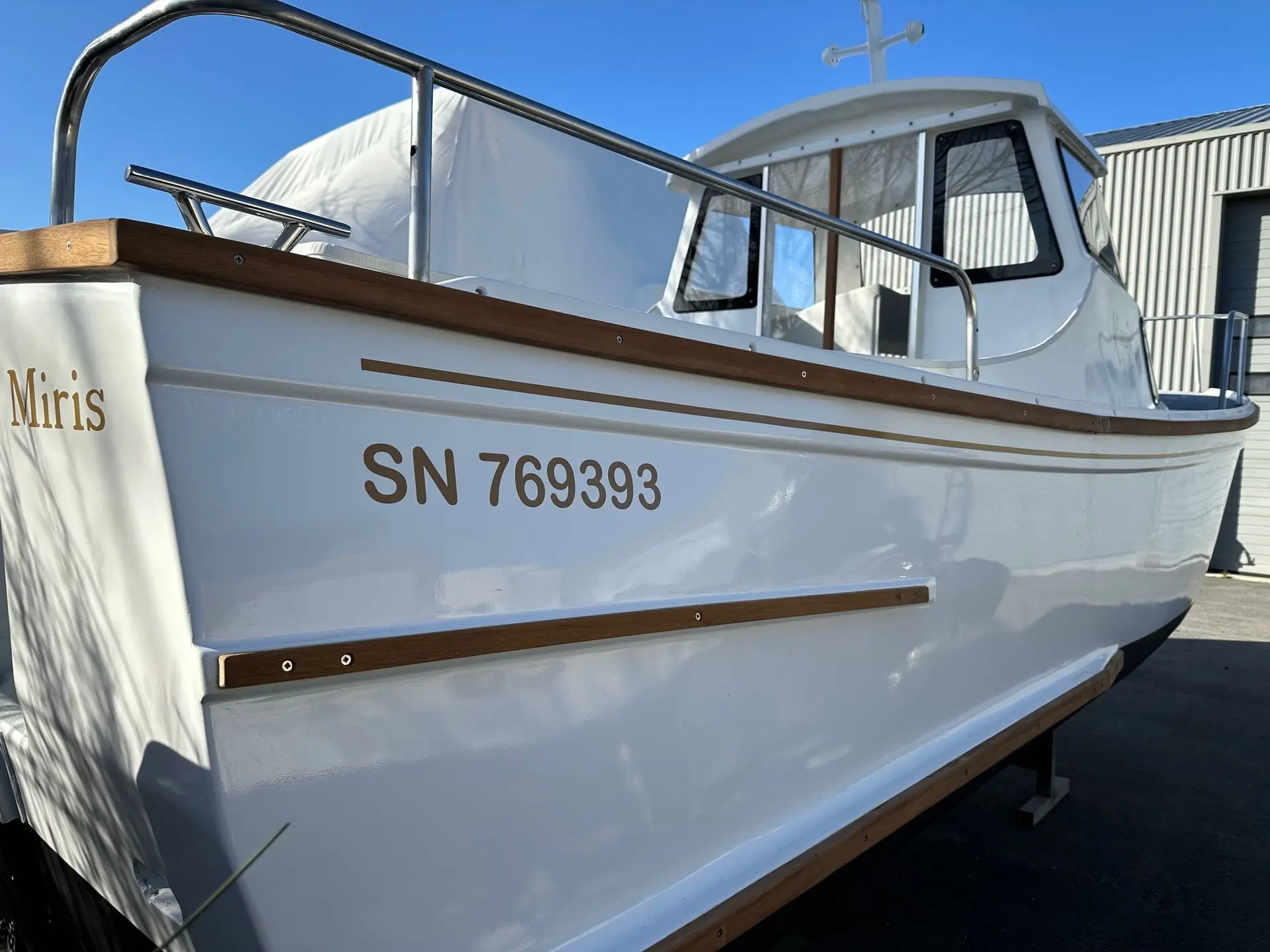 Kurunig 610 — Vue rapprochée du flanc d’un bateau blanc nommé Miris, avec cabine et immatriculation.