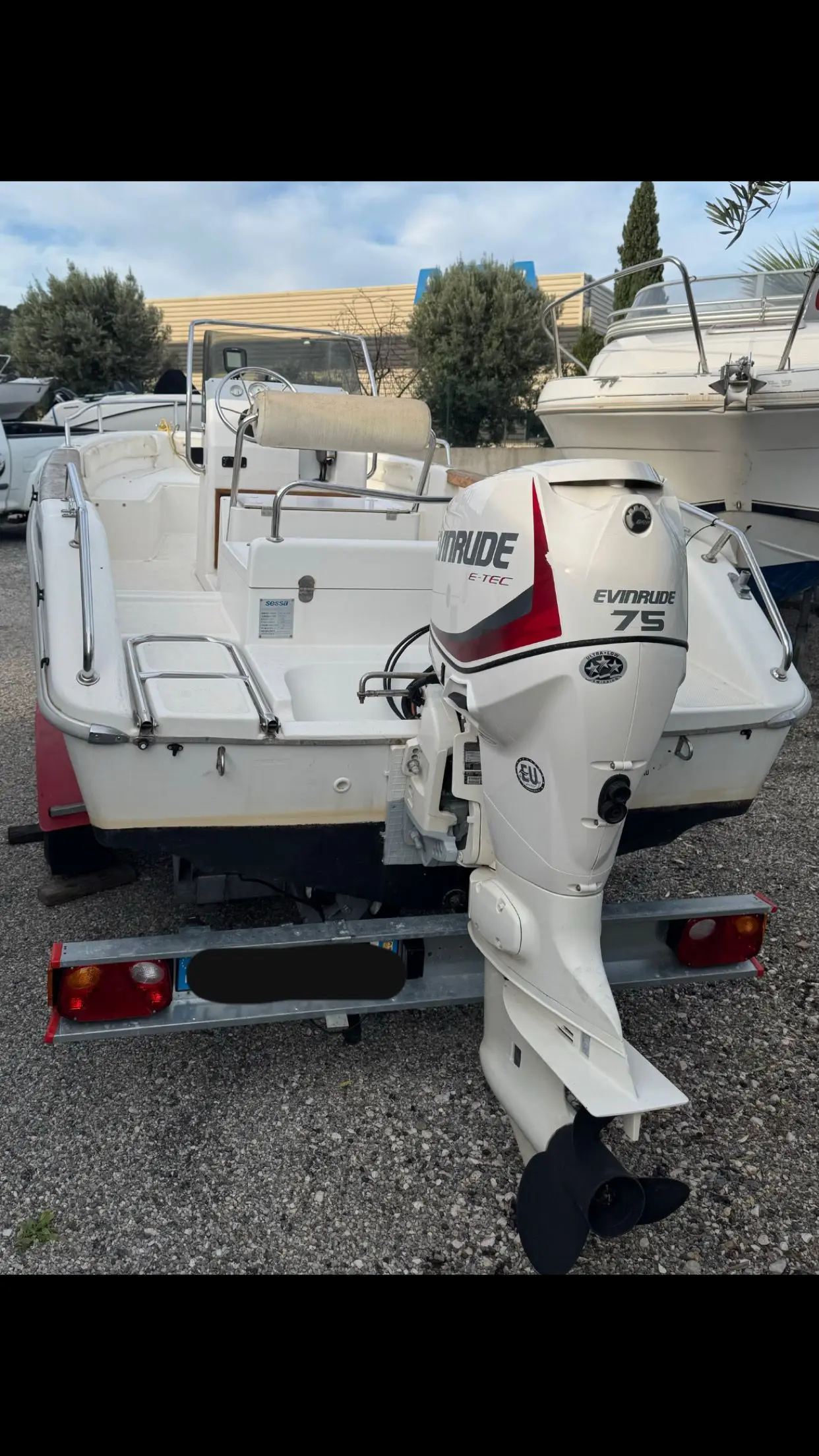 Sessa Marine Key Largo 18 — Vue arrière d’un bateau blanc hors de l’eau, avec son moteur hors-bord visible.