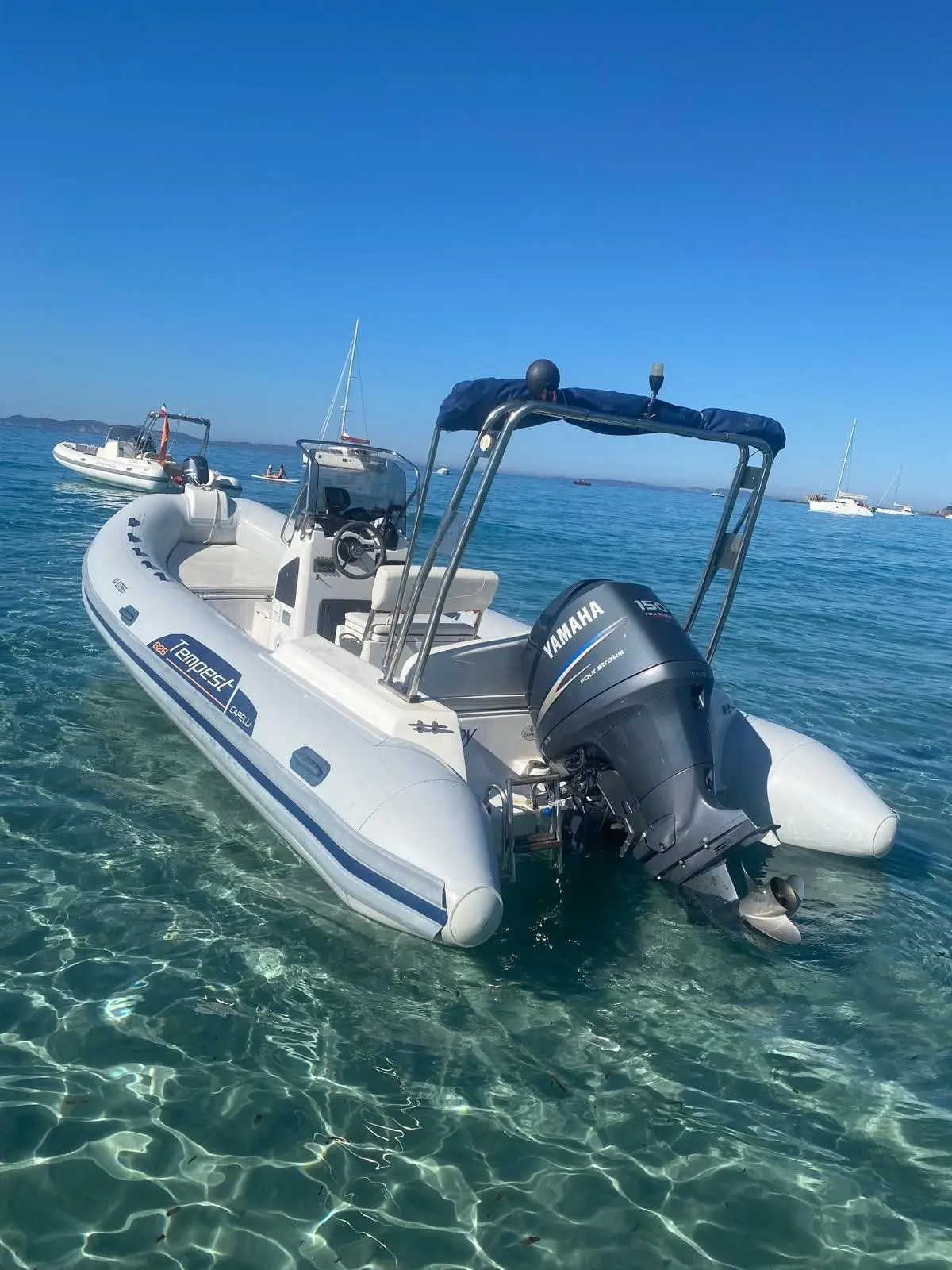 Capelli Tempest 626 — Semi-rigide blanc vu de trois quarts arrière sur une mer calme.