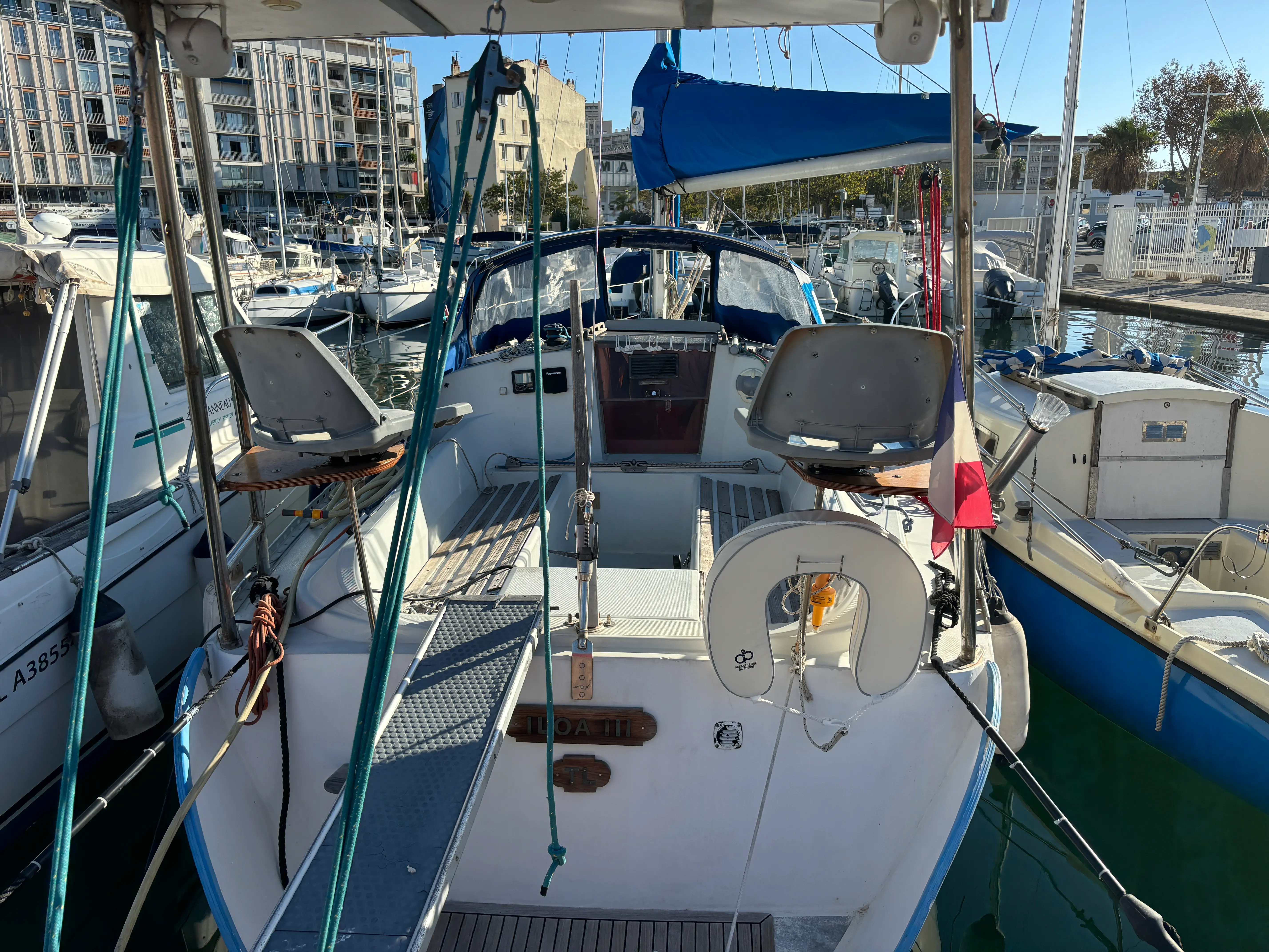 Kirie Feeling 286 — Vue arrière du cockpit d'un voilier amarré, avec capote et équipements de pont.