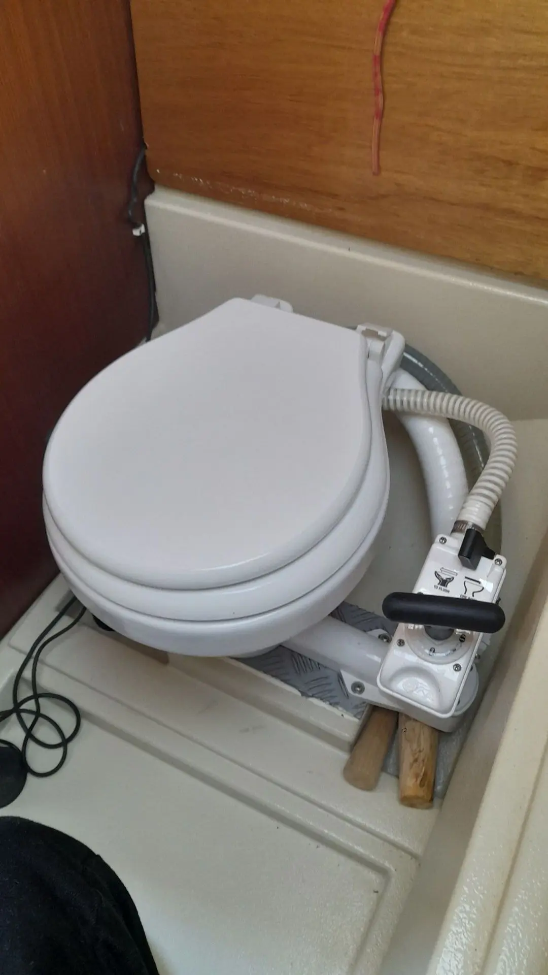 Etap 23 — Toilette marine manuelle installée dans un compartiment sanitaire.