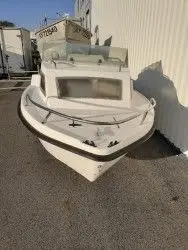 Jouandoudet Esturgeon — Bateau à cabine vu de trois quarts avant, stationné contre un bâtiment.