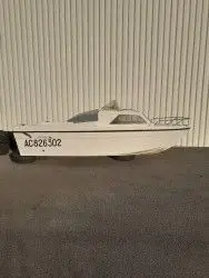 Jouandoudet Esturgeon — Bateau à cabine vu de profil dans un espace couvert.