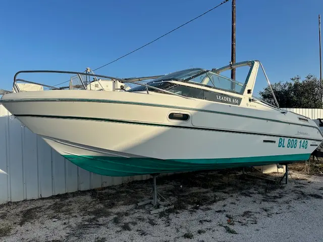 Jeanneau Leader 650 — Bateau à moteur blanc photographié à terre, vu de trois quarts.