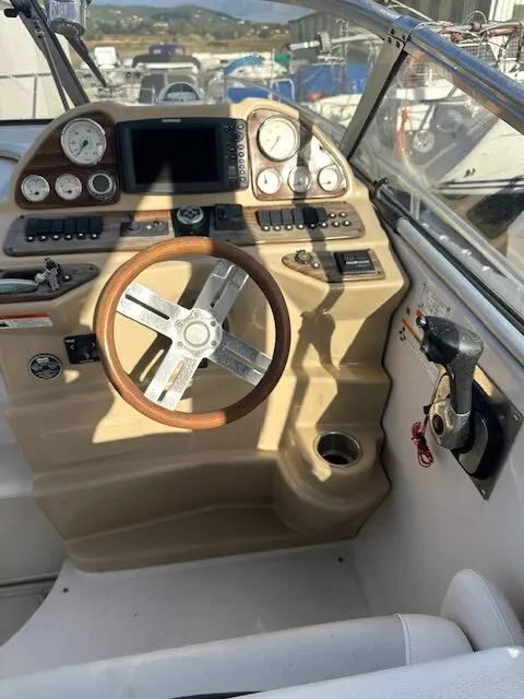 Glastron GS 289 — Poste de pilotage avec volant, instruments et commandes à bord du bateau.